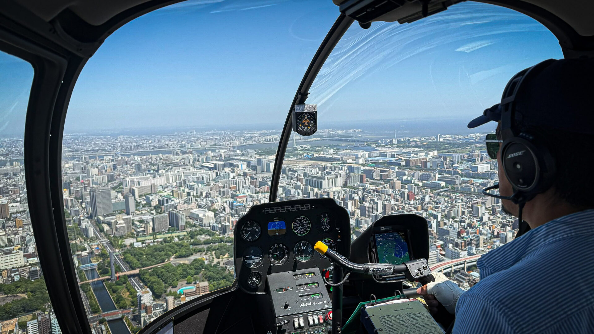 R44機内の計器越しに見える東京の街並み